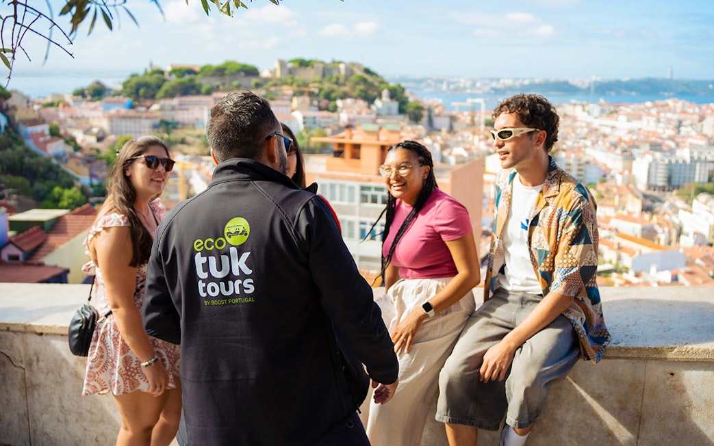 Tourists with guide overlooking Lisbon on an eco tuk tuk tour.