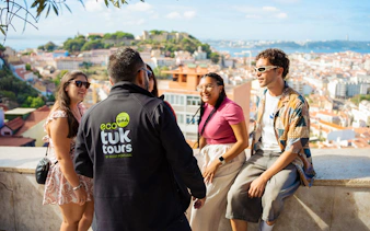 Tourists with guide overlooking Lisbon on an eco tuk tuk tour.