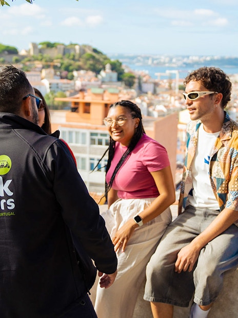 Tourists with guide overlooking Lisbon on an eco tuk tuk tour.