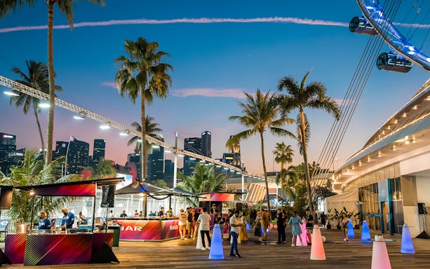 Hospitality area at Formula 1 Singapore Grand Prix 2025 with city skyline and palm trees.
