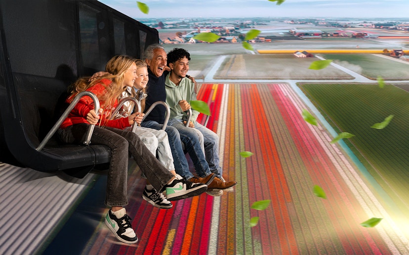 Tourists experiencing 5D ride at This Is Holland, flying over Dutch tulip fields.
