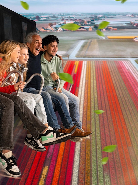Tourists experiencing 5D ride at This Is Holland, flying over Dutch tulip fields.