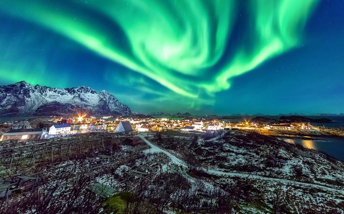 Northern Lights over snowy Tromso landscape on Northern Lights Chase Tour, Norway.