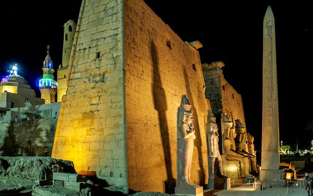 Karnak Temple illuminated at night with statues and obelisk, Luxor, Egypt.
