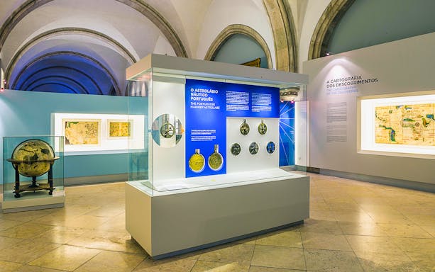 Astrolabes and maps on display inside the Maritime Museum exhibit.