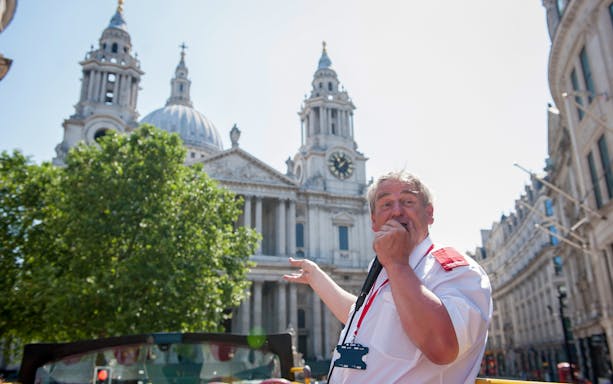 Tour guide speaking in front of St. Paul's Cathedral, London.