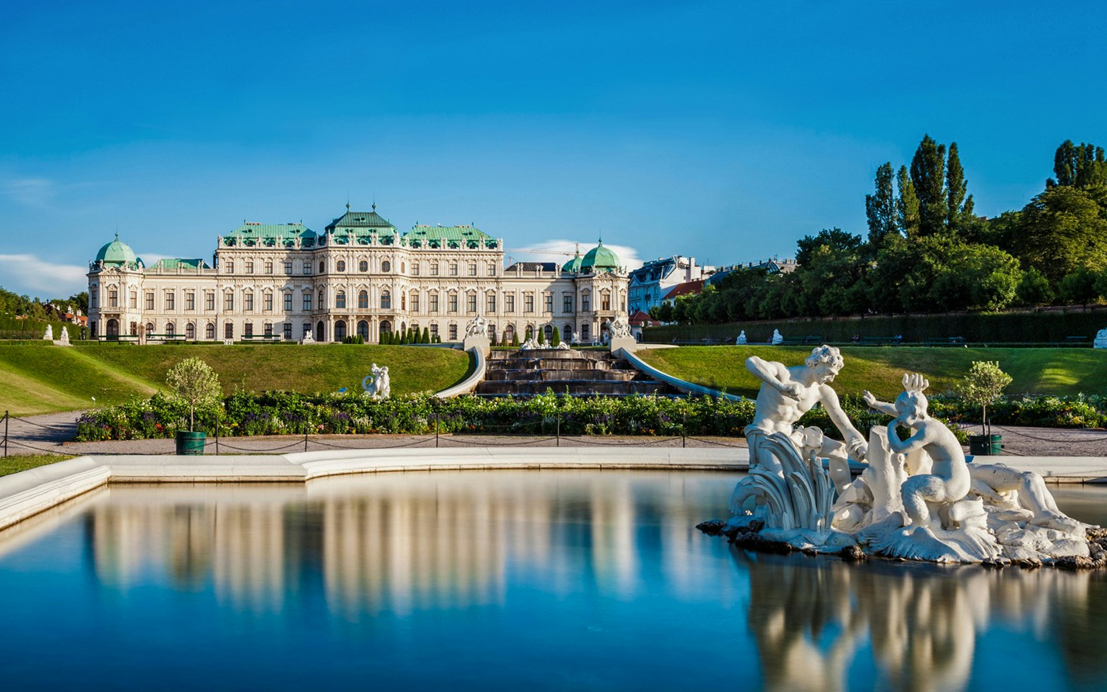 Statues in the gardens of Upper Belvedere Palace, Vienna, with palace in background.
