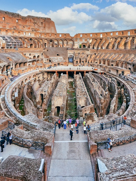 Tourists exploring the Colosseum's underground chambers in Rome with the Rome Super Pass.