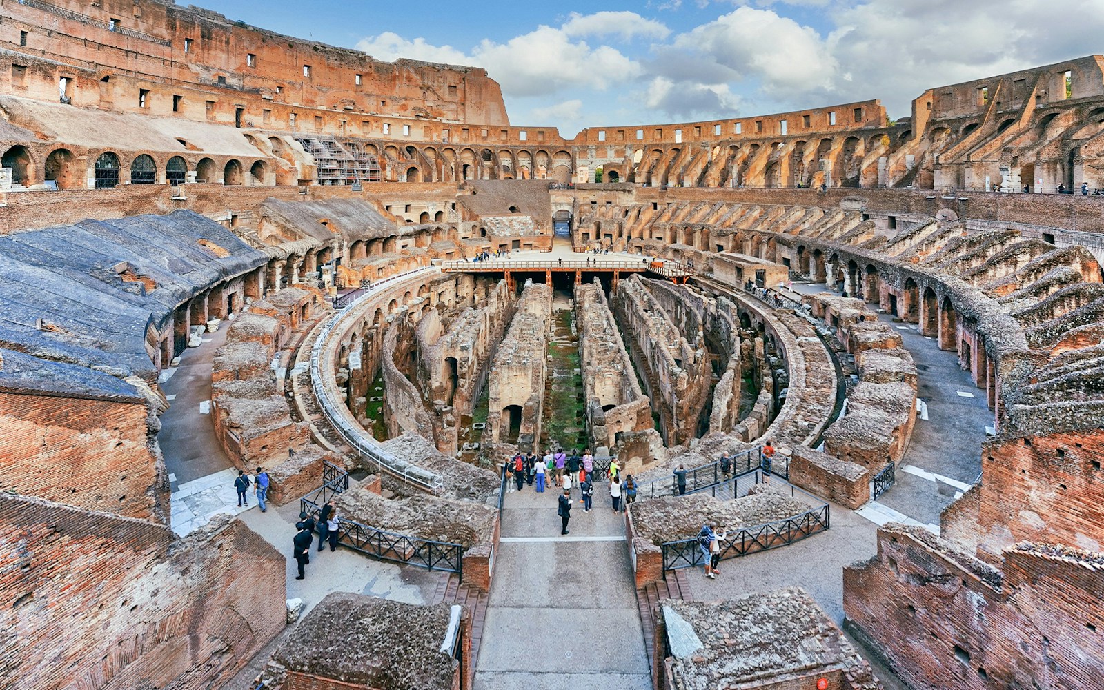 Tourists exploring underground chambers of the Colosseum, Rome, with exclusive Rome Super Pass.