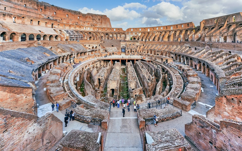 Tourists exploring the Colosseum's underground chambers in Rome with the Rome Super Pass.
