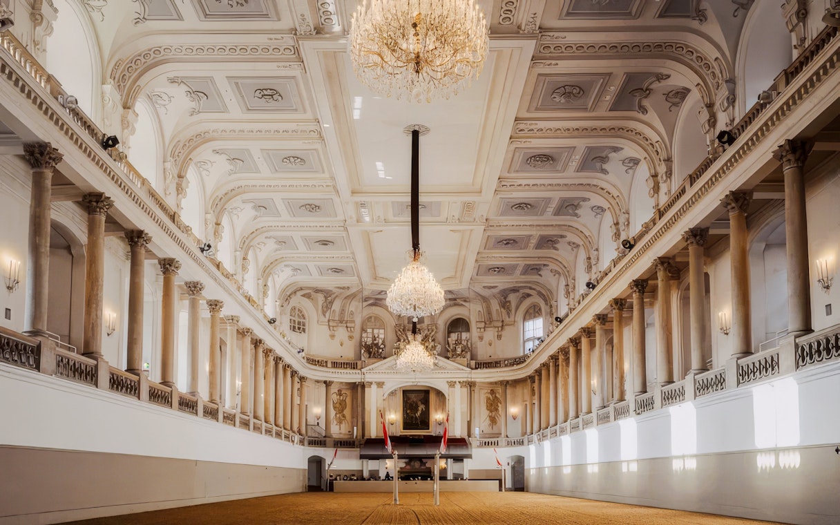Winter Riding School's grand hall with ornate chandeliers and classical architecture in Vienna.