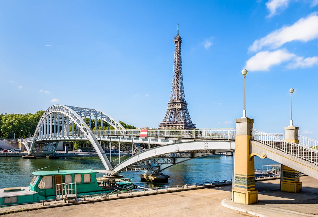 Debilly footbridge spanning the Seine River in Paris, with the Eiffel Tower visible in the background.