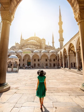 Visitor walking towards the Blue Mosque courtyard in Istanbul, Turkey.