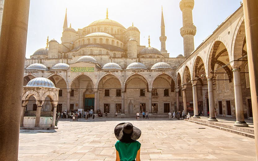 Visitor walking towards the Blue Mosque courtyard in Istanbul, Turkey.