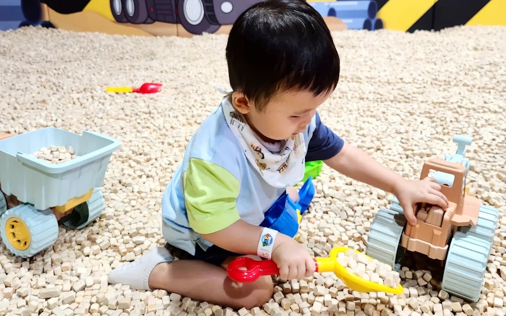 Child playing with toy truck at Tayo Station indoor playground.