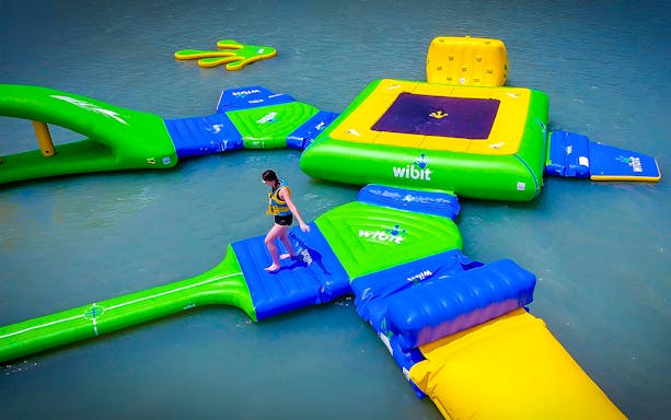 Floating water park at Paradise 101, Langkawi with person navigating inflatable course.