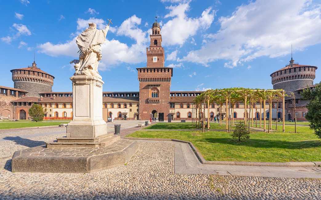 Sforza Castle courtyard with statue and towers, Milan, Italy.
