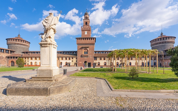 Sforza Castle courtyard with statue and towers, Milan, Italy.