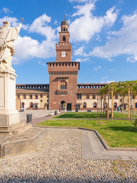 Sforza Castle courtyard with statue and towers, Milan, Italy.