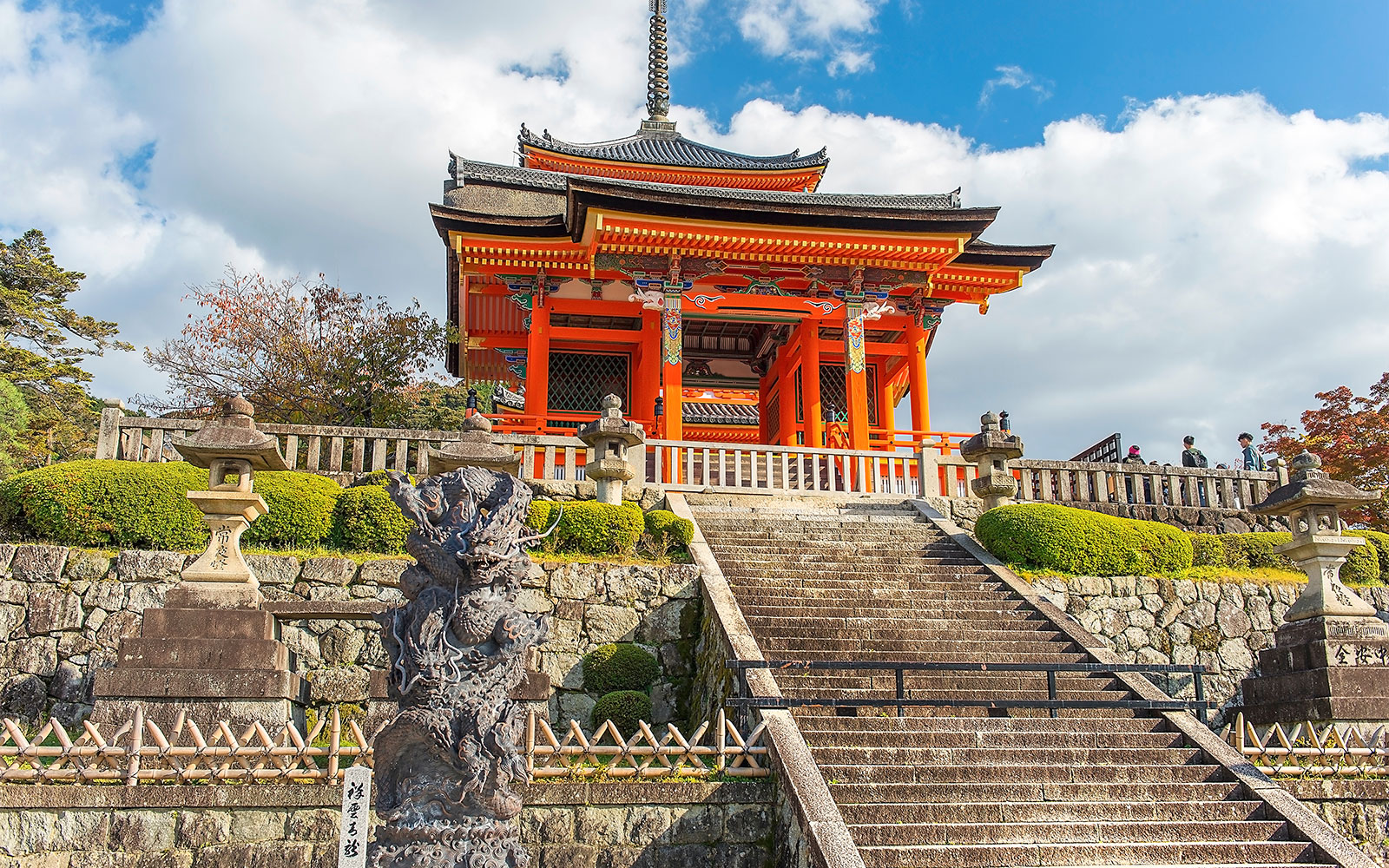 Kyoto temple with red pagoda and stone lanterns on a cultural tour.