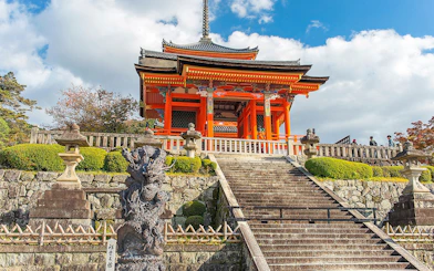 Kyoto temple with red pagoda and stone lanterns on a cultural tour.