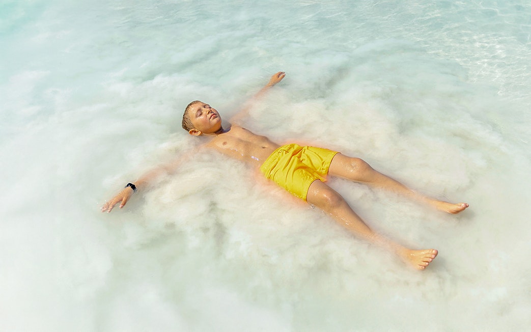 Child floating in Pamukkale thermal pools, Turkey.
