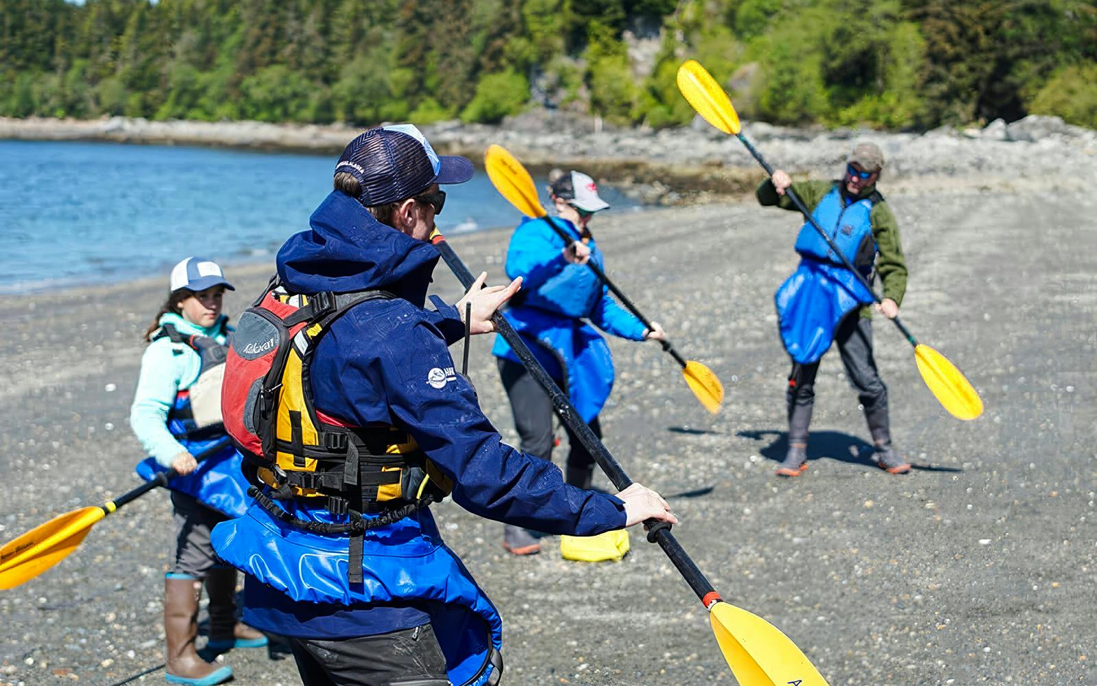 Kayakers preparing on a beach for a whale-watching tour in Juneau.