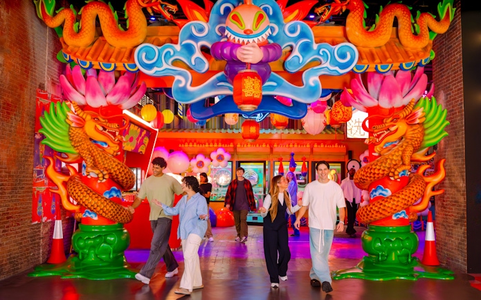 Colorful entrance with dragons and lanterns at House Of Hype, people walking through.