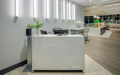 Reception area of Aspire Lounge at San Diego International Airport with seating and refreshments.
