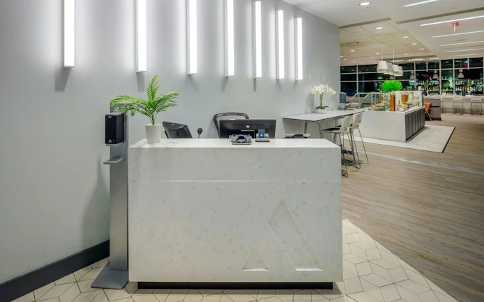 Reception area of Aspire Lounge at San Diego International Airport with seating and refreshments.