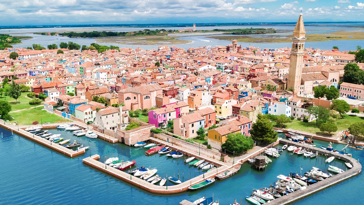 Aerial view of Burano island's colorful houses during a helicopter tour over the Venice lagoon.