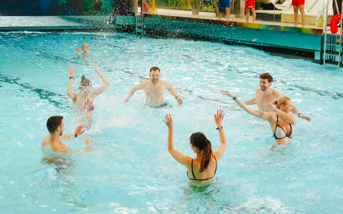 People enjoying the wave pool at Galaxy Zone, Therme Bucharest at night.