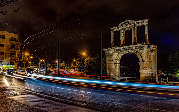 Hadrian's Arch illuminated at night during Athens bus tour.