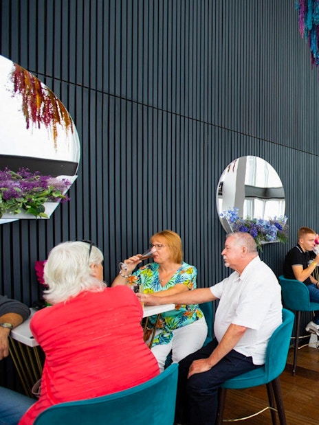People enjoying drinks at a table with city views from the top of the Shard in London.