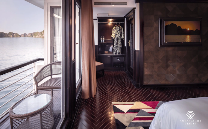 Luxurious cabin interior with balcony view on Ambassador Premium cruise in Halong Bay, Vietnam.