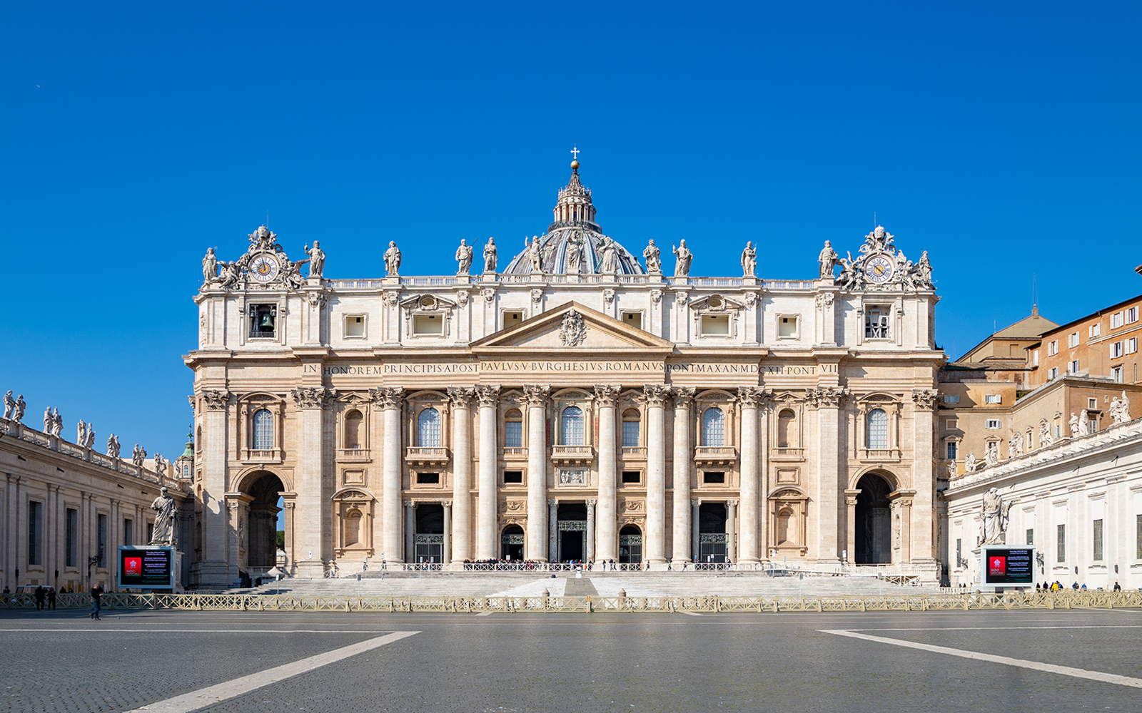 St. Peter's Basilica and Dome in Rome with tourists exploring the Vatican City.