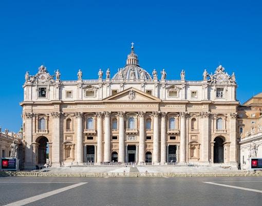 St. Peter's Basilica and Dome in Rome with tourists exploring the Vatican City.