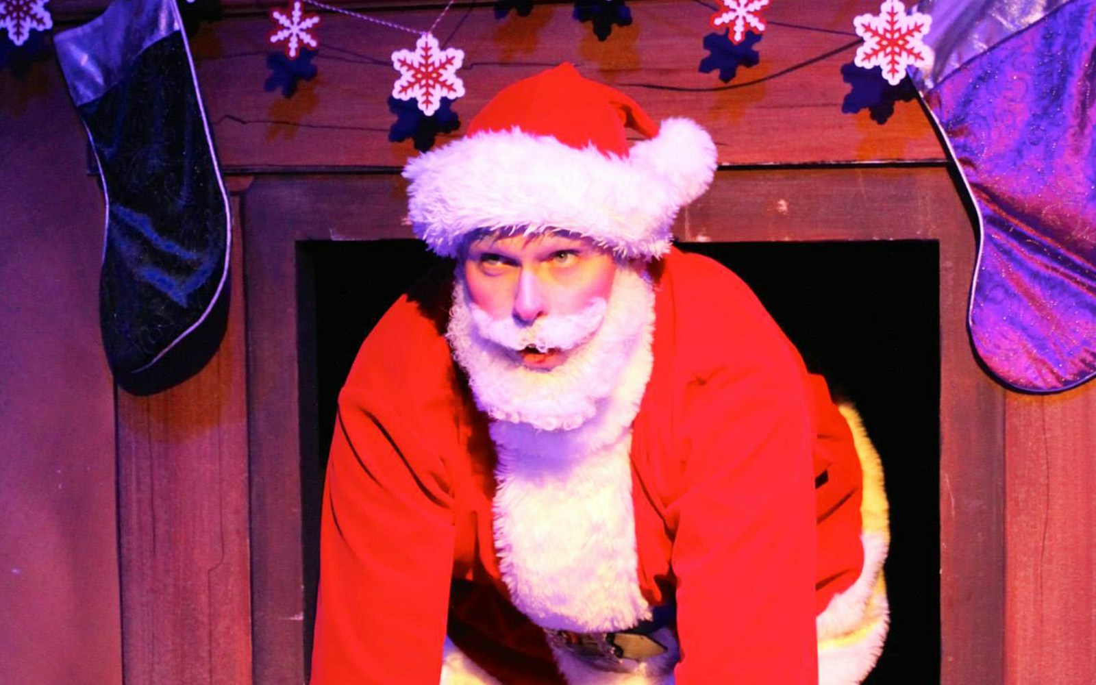 Father Christmas in a festive setting, London, holding a list with a humorous expression.