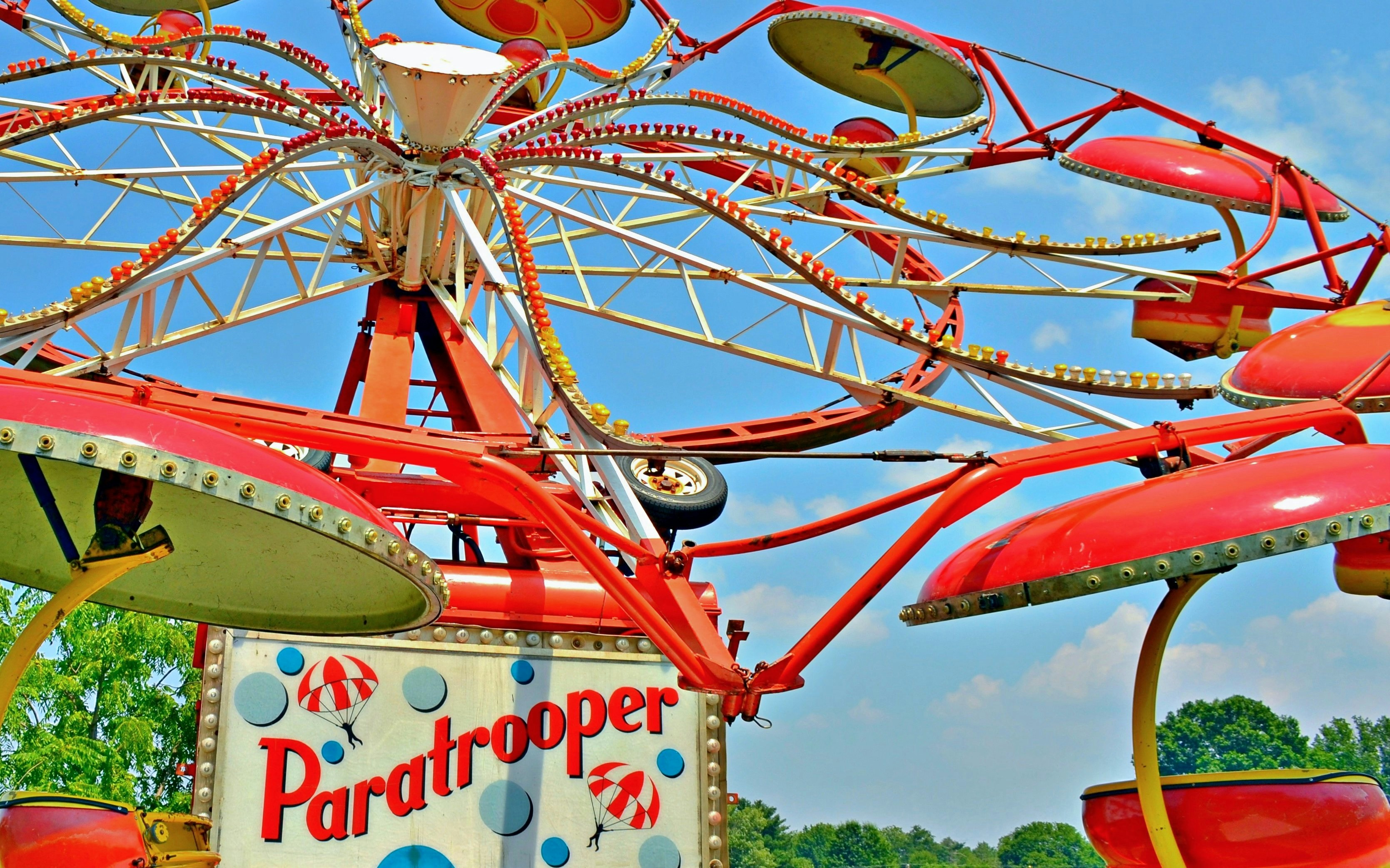 Paratrooper ride with red and yellow seats in amusement park.