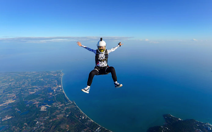 Skydiver over Pattaya coastline during Ocean View Tandem Skydive at 13,000 ft.