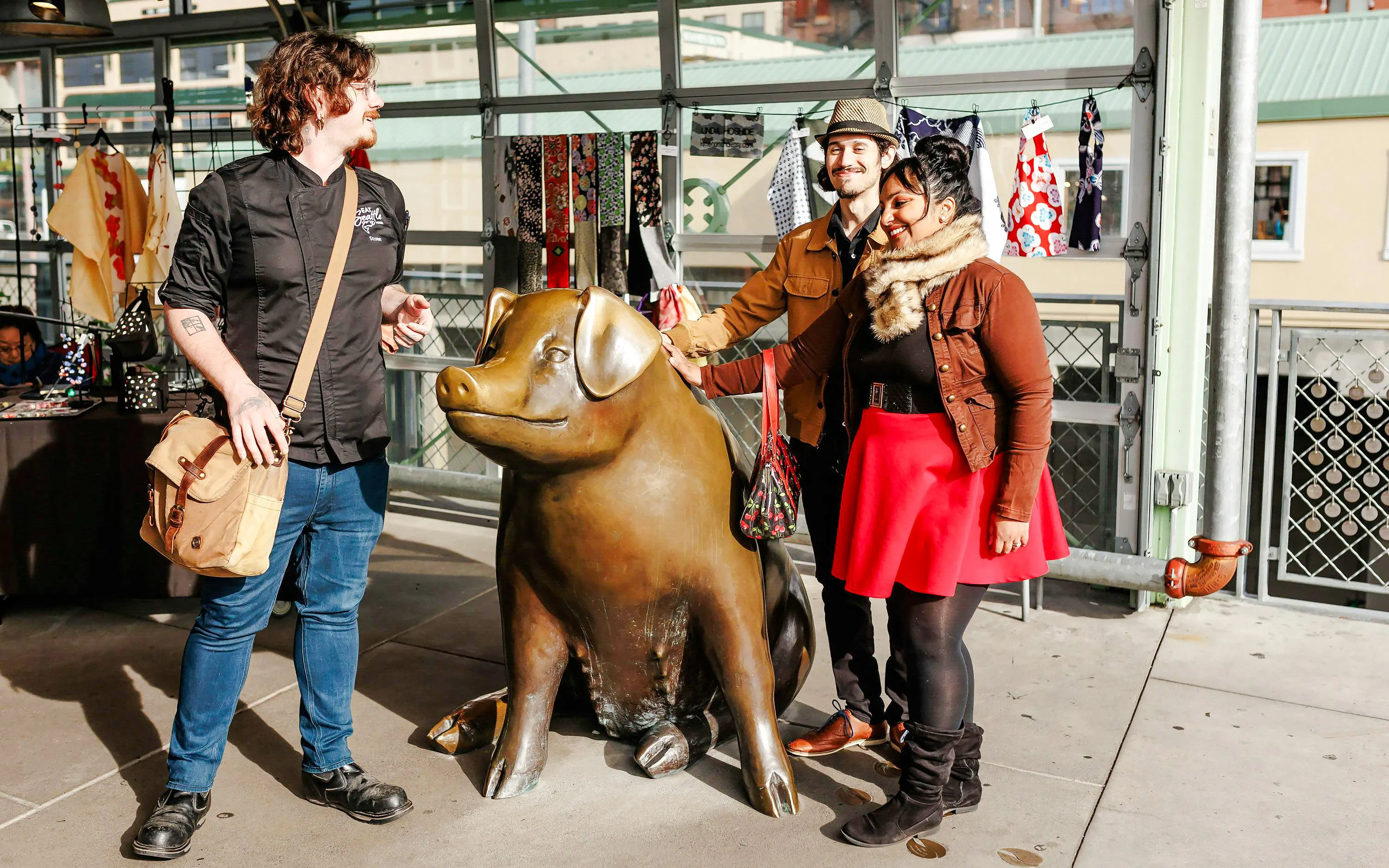 Visitors with a guide at Rachel the Piggy Bank statue, Pike Place Market, Seattle.