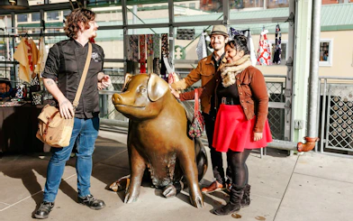 Visitors with a guide at Rachel the Piggy Bank statue, Pike Place Market, Seattle.