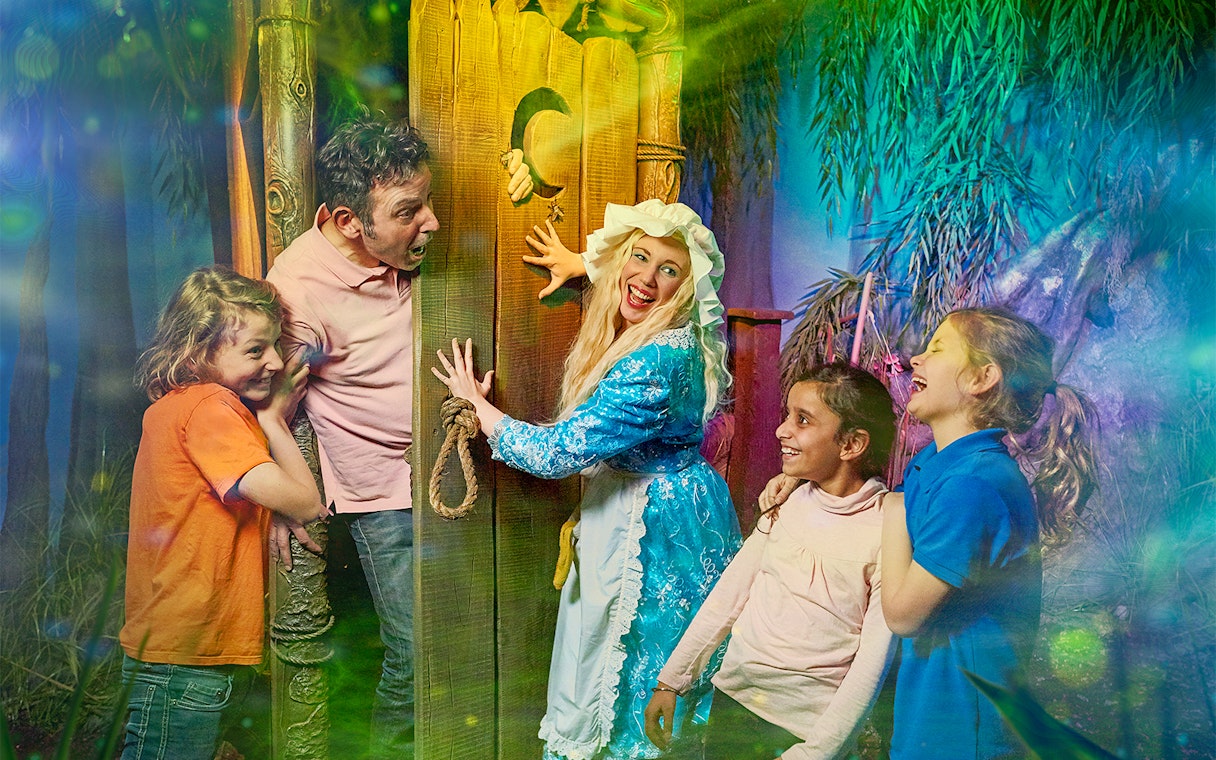 Visitors enjoying interactive scene at Shrek’s Adventure! London with a costumed character.
