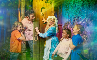 Visitors enjoying interactive scene at Shrek’s Adventure! London with a costumed character.