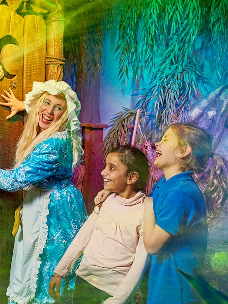 Visitors enjoying interactive scene at Shrek’s Adventure! London with a costumed character.