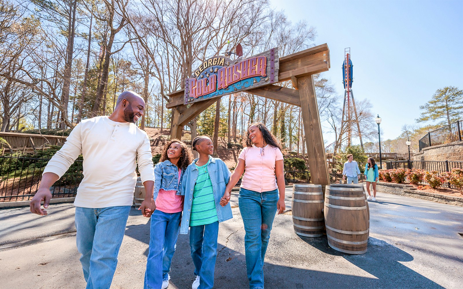 Family walking under Georgia Gold Rusher sign at Six Flags Over Georgia.