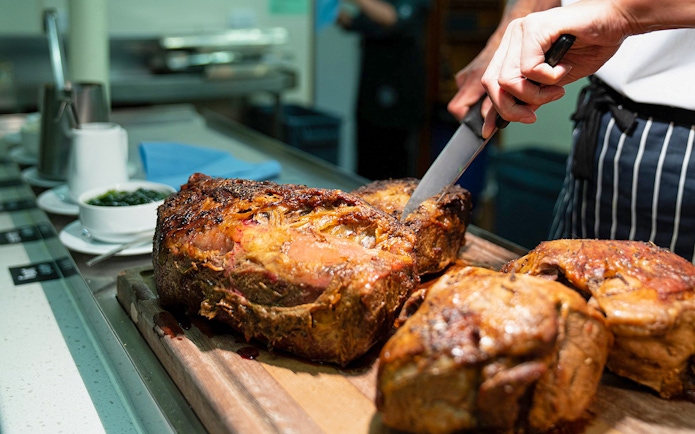 Carving roast beef on Overnight Milford Sound Cruise dining experience.