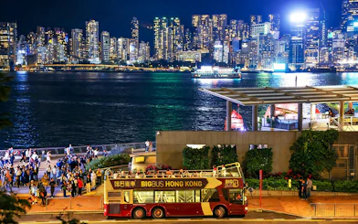 Big Bus tour in Hong Kong with Kowloon skyline at night.