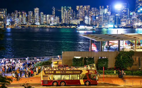 Big Bus tour in Hong Kong with Kowloon skyline at night.