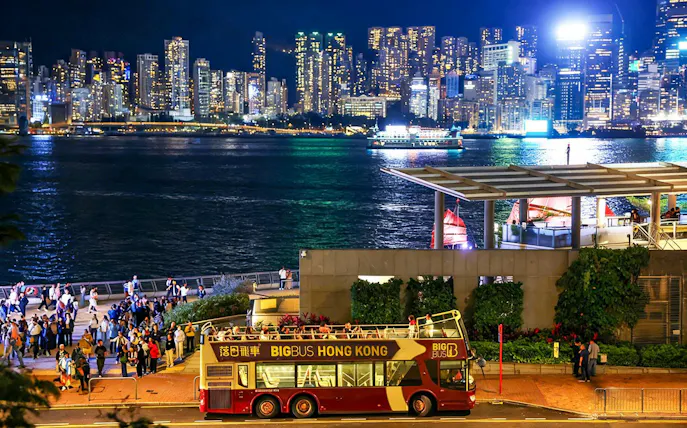Big Bus tour in Hong Kong with Kowloon skyline at night.